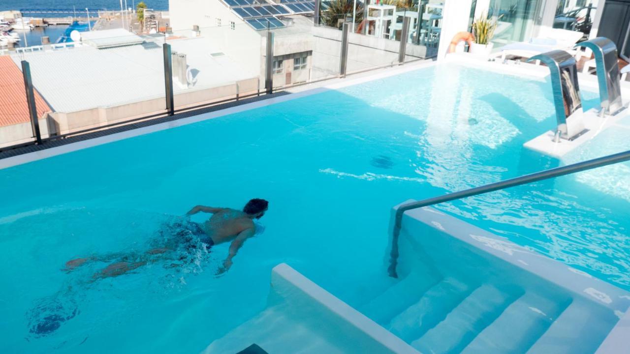 Gran Hotel Nagari Boutique&Spa Vigo Bagian luar foto A man swimming in a rooftop pool